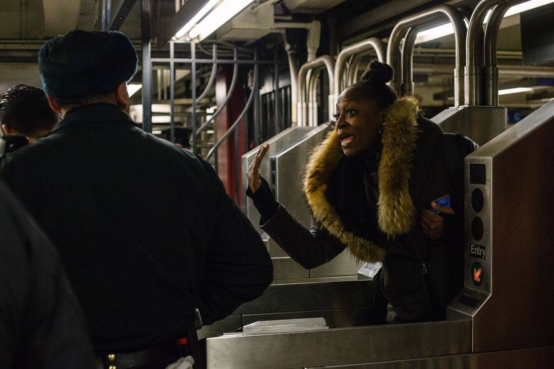 A woman speaks to the police as she goes through the turnstile.